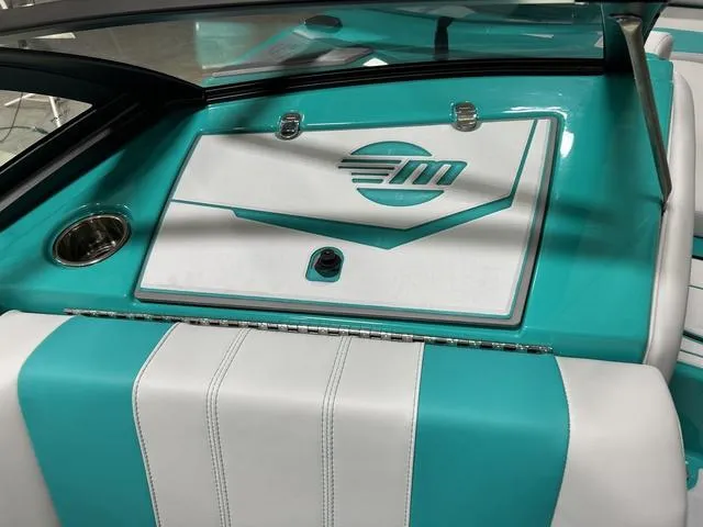 Slide: The Image of 2023 Malibu 21 LX boat interior with teal and white upholstery. - 19