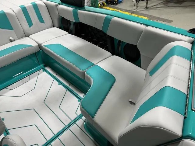 Slide: The Image of 2023 Malibu 21 LX boat interior with teal and white seating arrangement. - 24