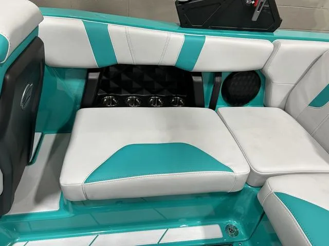 Slide: The Image of 2023 Malibu 21 LX boat interior with teal and white seating, modern design. - 25