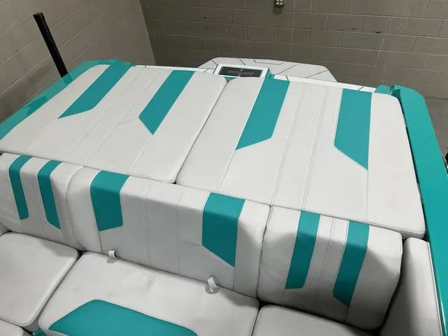 Slide: The Image of 2023 Malibu 21 LX boat interior with white and teal upholstery design. - 26