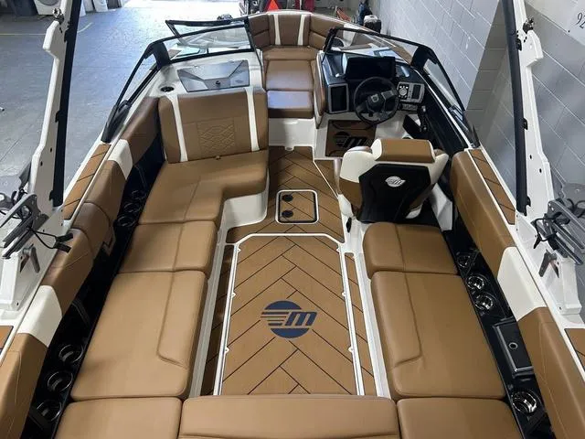 Slide: The Image of 2024 Malibu 23 LSV boat interior with tan seating and modern dashboard. - 10