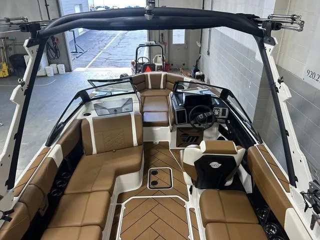 Slide: The Image of 2024 Malibu 23 LSV boat interior with tan seating and modern dashboard. - 11