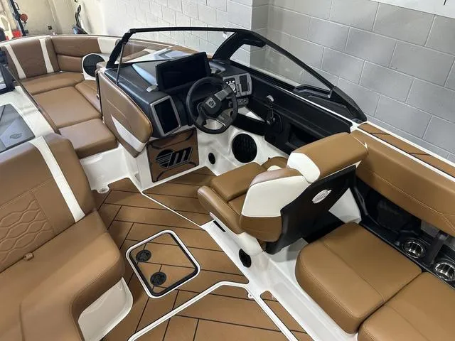 Slide: The Image of 2024 Malibu 23 LSV boat interior with brown seating and modern dashboard. - 14