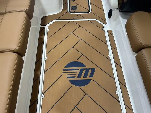 Slide: The Image of 2024 Malibu 23 LSV boat interior with brown seating and logo on deck. - 15