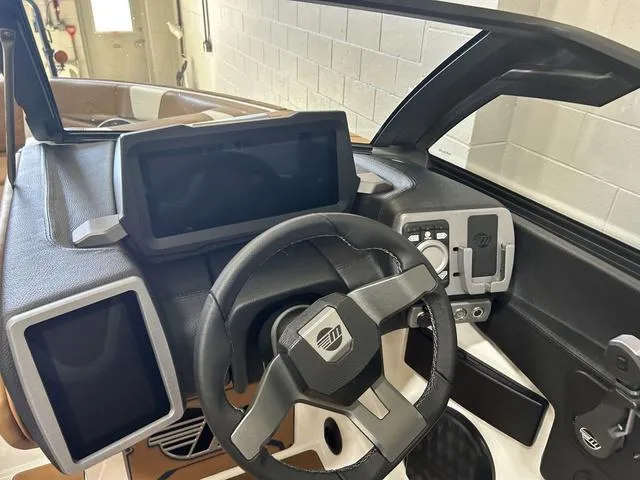 Slide: The Image of 2024 Malibu 23 LSV boat dashboard with modern steering wheel and digital displays. - 17