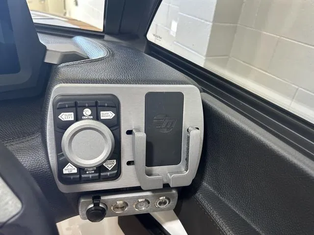 Slide: The Image of 2024 Malibu 23 LSV boat dashboard with control panel and phone holder. - 19