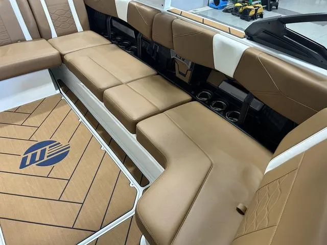 Slide: The Image of 2024 Malibu 23 LSV boat interior with tan leather seating and custom flooring. - 22