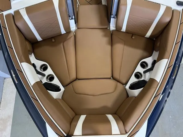 Slide: The Image of 2024 Malibu 23 LSV boat interior with tan and white cushioned seating. - 26
