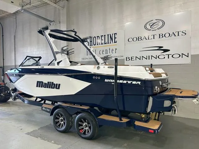 Slide: The Image of 2024 Malibu 23 LSV boat on trailer in showroom, featuring sleek design and modern features. - 3