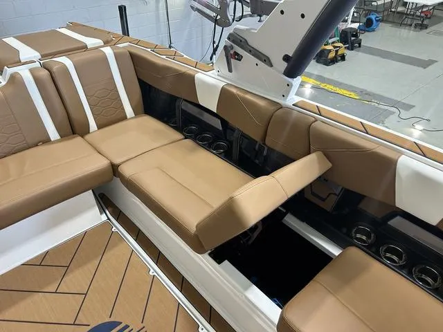 Slide: The Image of 2024 Malibu 23 LSV boat interior with tan seating and storage compartments. - 30