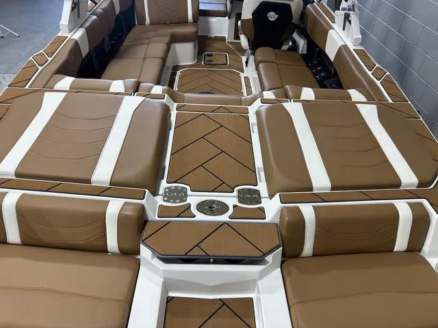 Slide: The Image of 2024 Malibu 23 LSV boat interior with brown and white cushioned seating. - 8