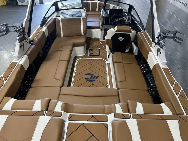 Slide: The Image of 2024 Malibu 23 LSV boat interior with luxurious brown and white seating and modern dashboard. - 9