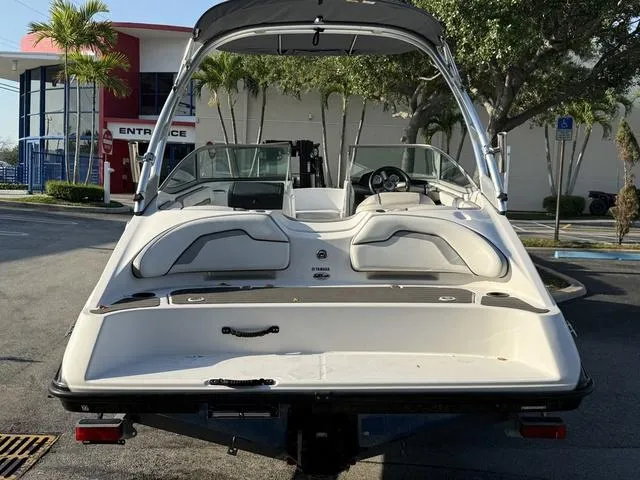 Slide: The Image of 2017 Yamaha AR190 boat, rear view, parked outdoors near palm trees and a building entrance. - 23