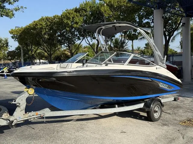 Slide: The Image of 2017 Yamaha Boats AR190 on trailer, sleek design, black and blue hull, under sunny skies. - 25