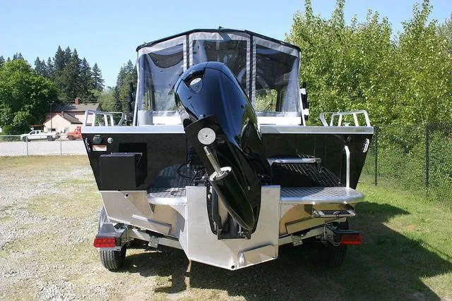 Slide: The Image of 2025 Thunder Jet 200 Luxor boat with outboard motor, parked on grass. - 4