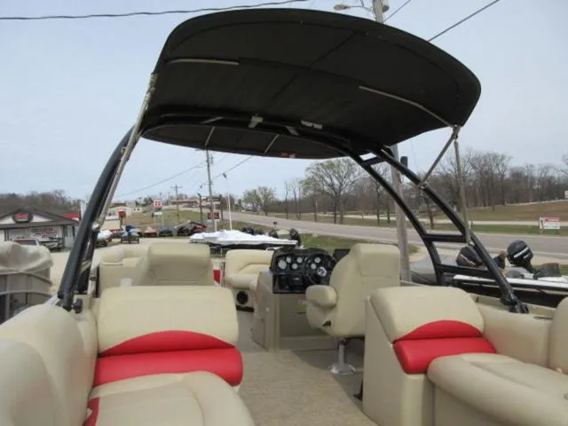 Slide: The Image of 2017 Landau 230C Atlantis Cruise Tritoon with beige and red seating, black canopy, and control console. - 11
