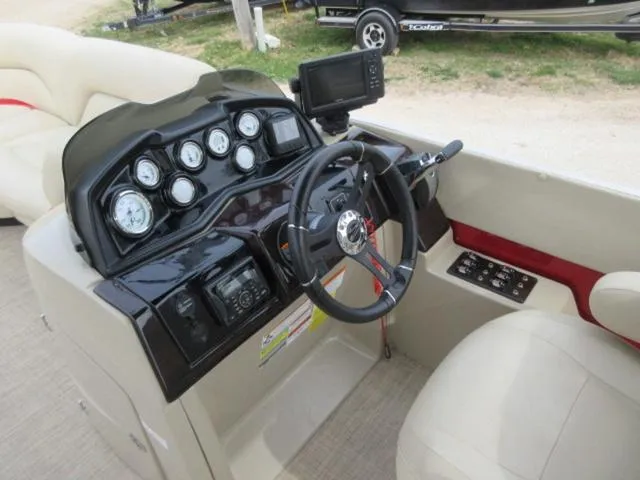Slide: The Image of 2017 Landau 230C Atlantis Cruise Tritoon dashboard with steering wheel and gauges. - 18