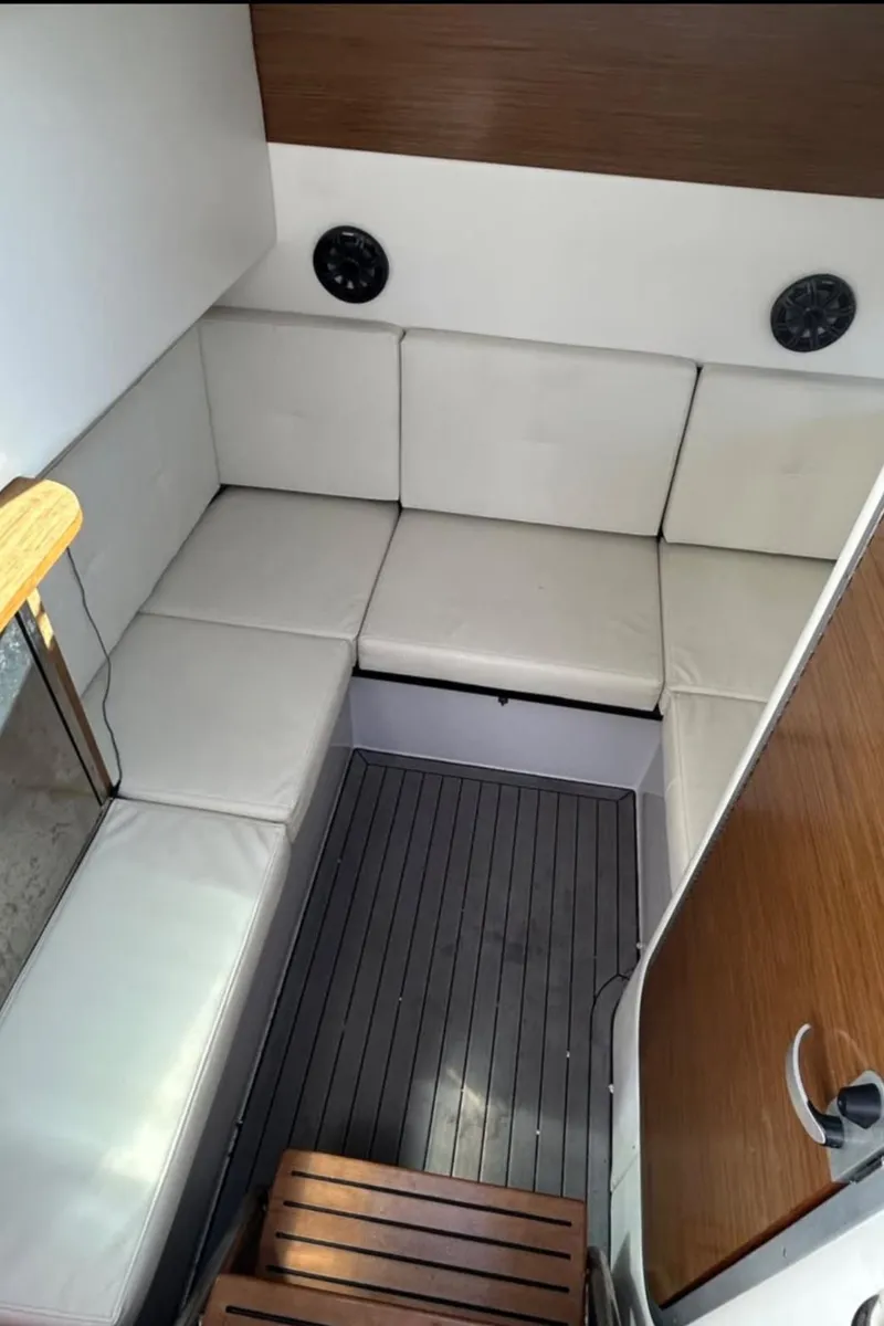 Slide: The Image of 2019 Cruisers Yachts 338 Outboard interior with white seating and wooden accents. - 6
