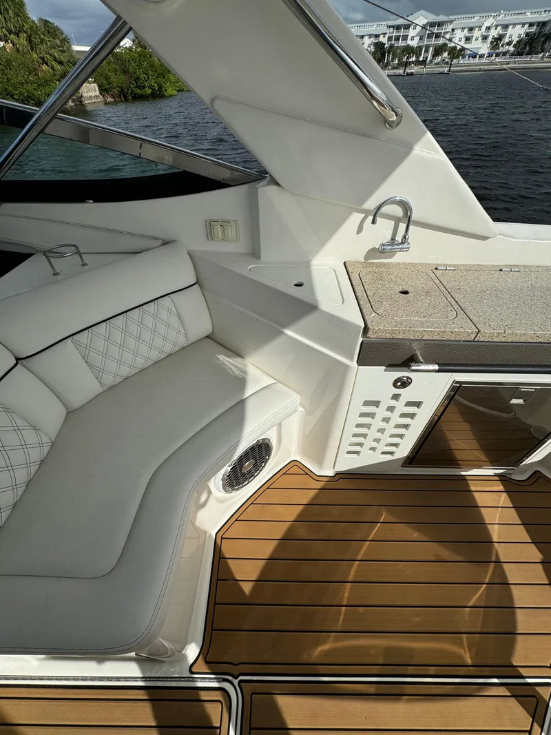 Slide: The Image of 2015 Sea Ray 350 SLX boat interior with seating, kitchenette, and wood flooring. - 11