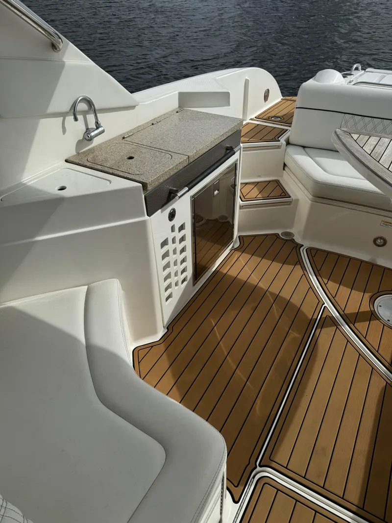 Slide: The Image of 2015 Sea Ray 350 SLX boat interior with teak flooring and kitchenette. - 15