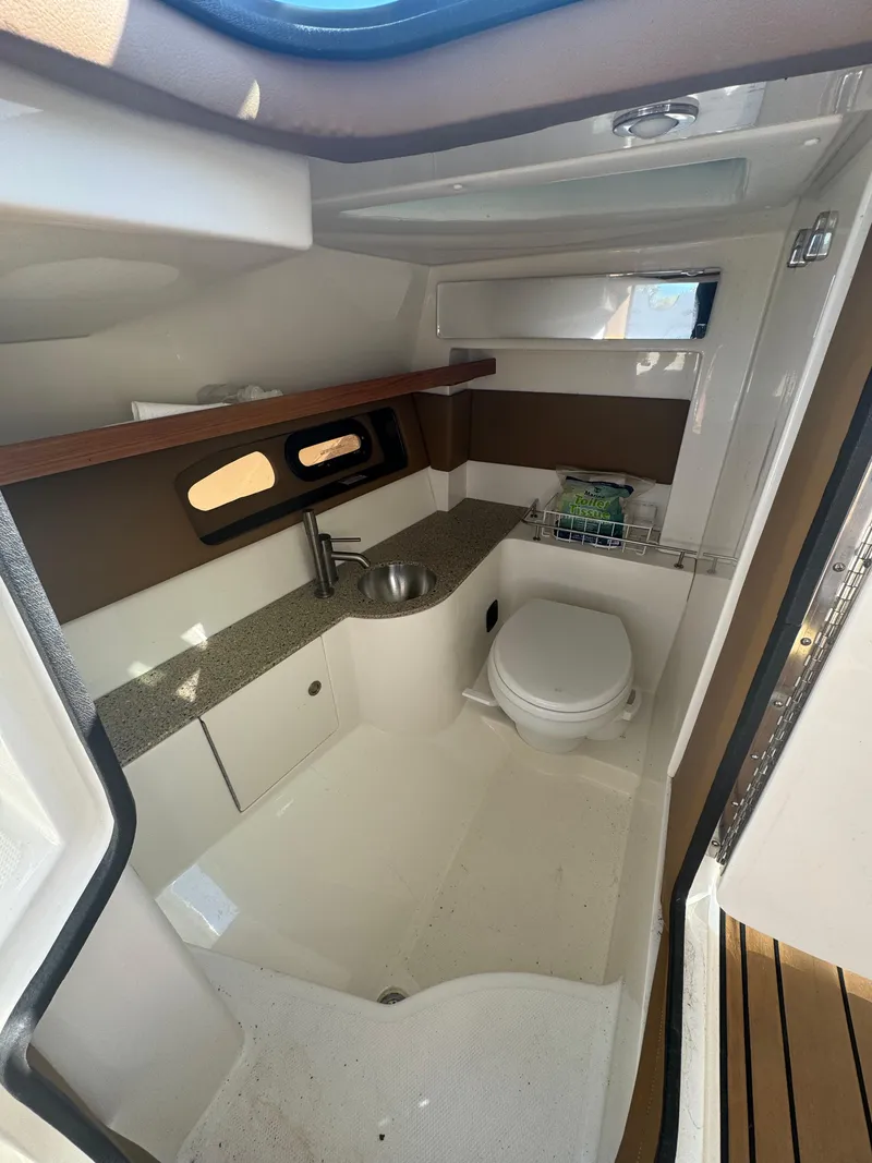 Slide: The Image of Interior of 2015 Sea Ray 350 SLX boat, featuring a compact bathroom with sink and toilet. - 20