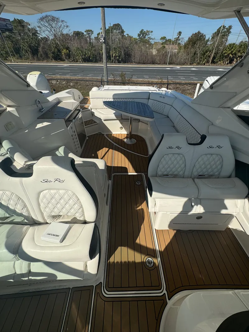 Slide: The Image of 2015 Sea Ray 350 SLX boat interior with white seating and wood flooring. - 22