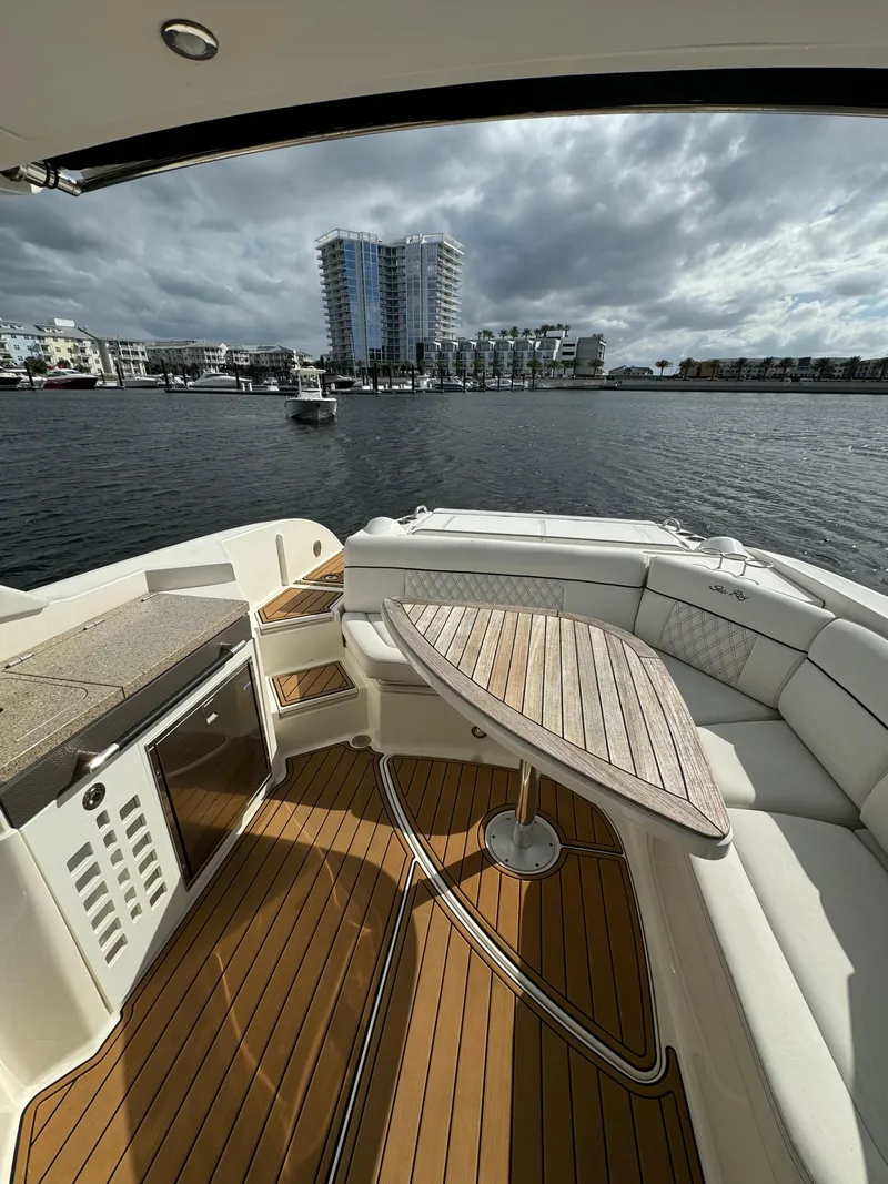 Slide: The Image of 2015 Sea Ray 350 SLX boat with elegant seating and waterfront cityscape view. - 6