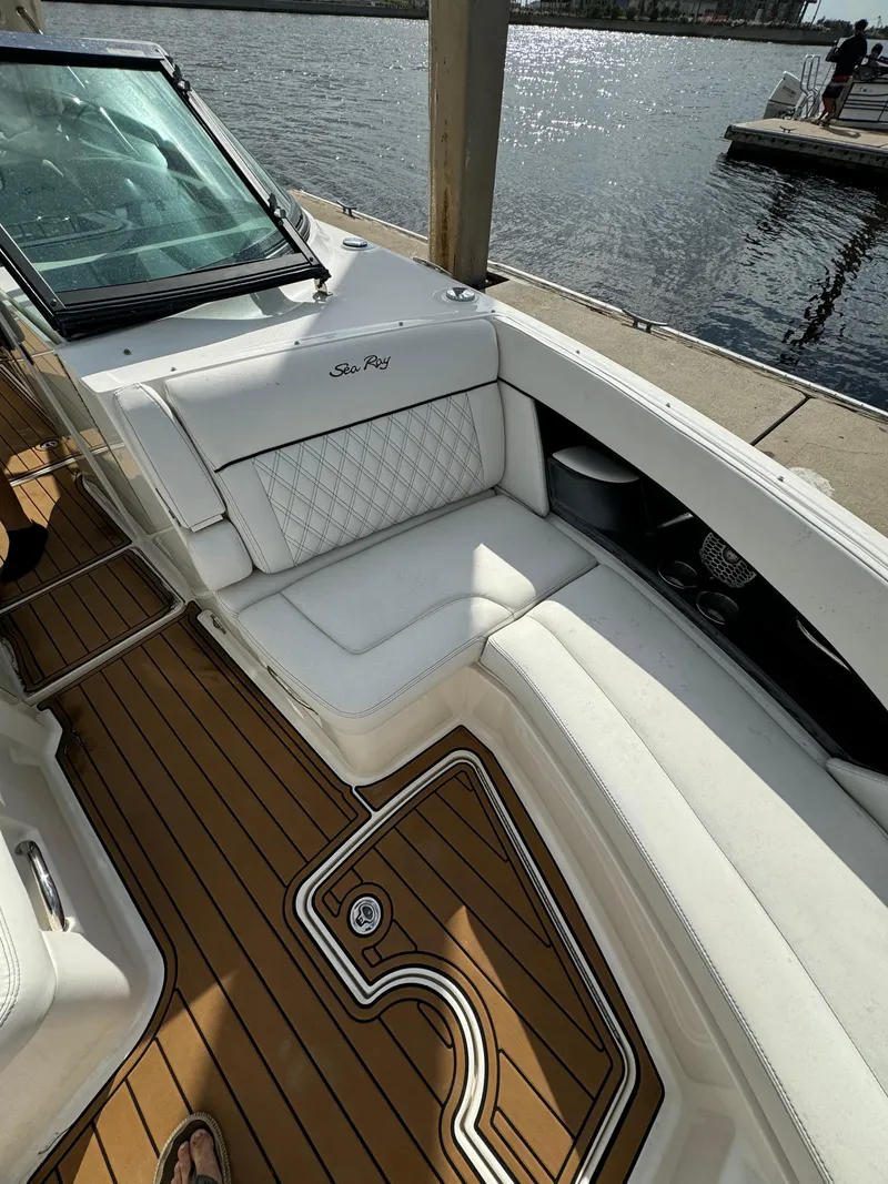 Slide: The Image of 2015 Sea Ray 350 SLX boat with white seating and wooden deck by the water. - 7