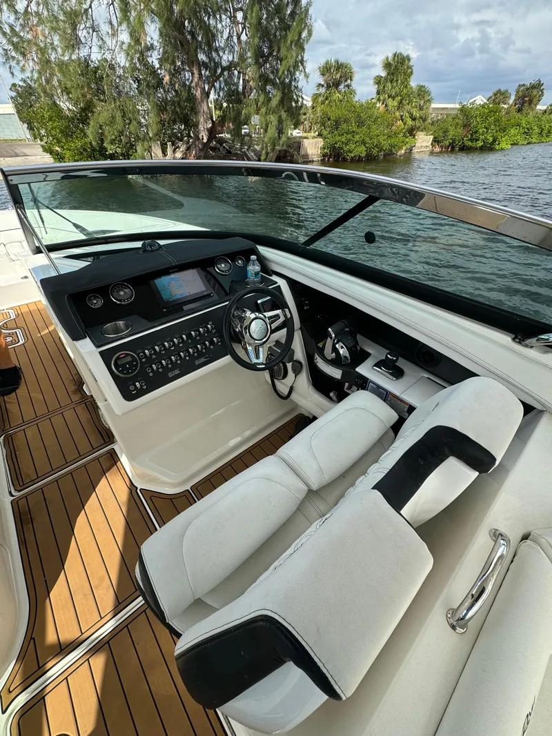 Slide: The Image of 2015 Sea Ray 350 SLX boat interior with sleek dashboard and comfortable seating. - 8