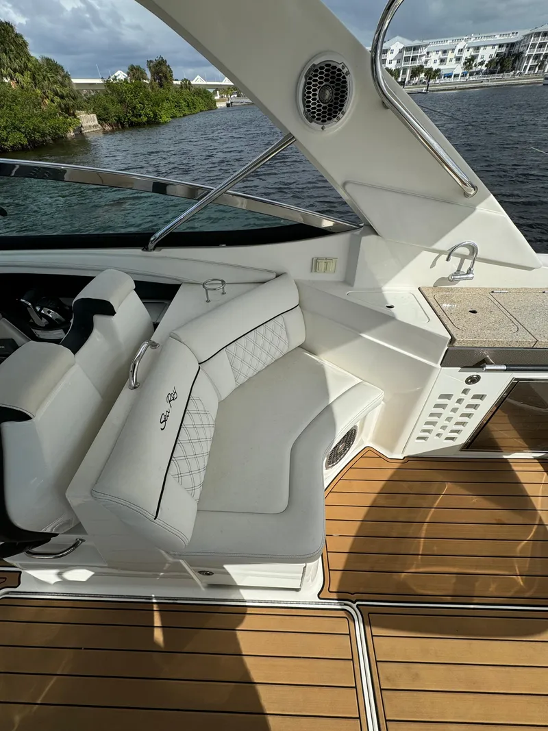 Slide: The Image of 2015 Sea Ray 350 SLX boat interior with white seating and wooden deck. - 9