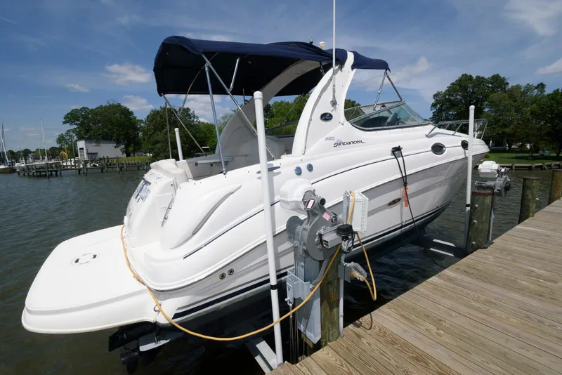 Slide: The Image of 2005 Sea Ray 280 Sundancer boat docked with blue canopy on a sunny day. - 0