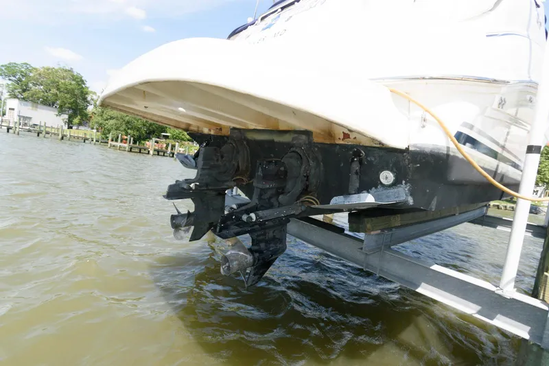 Slide: The Image of 2005 Sea Ray 280 Sundancer boat on lift, showing dual propellers and stern drive. - 14