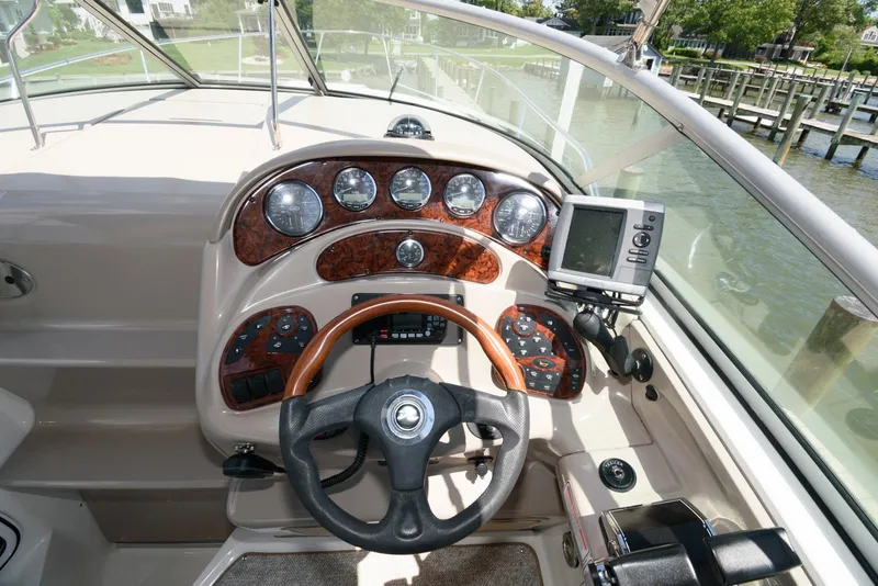 Slide: The Image of 2005 Sea Ray 280 Sundancer helm with wood accents and navigation equipment. - 5