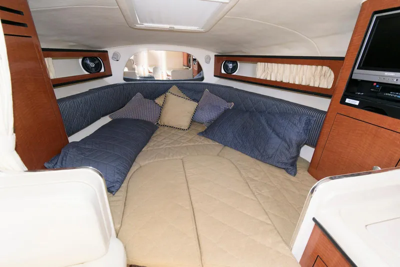 Slide: The Image of 2005 Sea Ray 280 Sundancer cabin interior with cozy bedding and entertainment system. - 7
