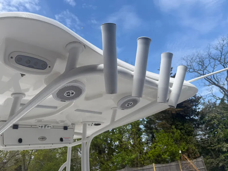 Slide: The Image of Tidewater 230 LXF 2015 boat roof with rod holders and speakers under blue sky. - 10