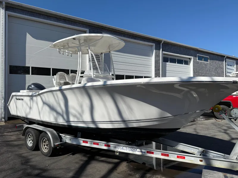 Slide: The Image of 2015 Tidewater 230 LXF boat on trailer, parked outside a garage. - 4