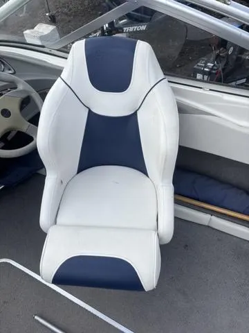 Slide: The Image of Captain's seat of a 2006 Bayliner 205 MX boat, featuring blue and white upholstery. - 13