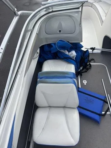 Slide: The Image of 2006 Bayliner 205 MX boat interior with white and blue seating and storage area. - 14