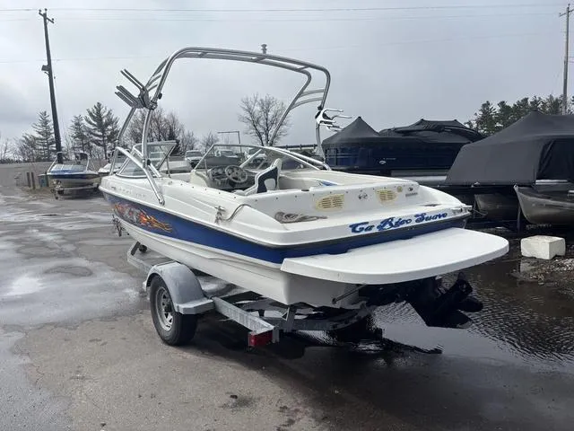 Slide: The Image of 2006 Bayliner 205 MX boat on trailer, parked outdoors on a wet surface. - 5