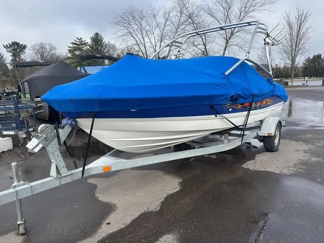 Slide: The Image of 2006 Bayliner 205 MX boat on trailer, covered with blue tarp, parked outdoors. - 8
