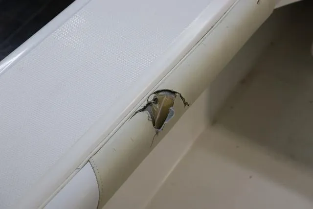 Slide: The Image of Damaged upholstery on 2007 Everglades 223CC boat seat, showing a tear and exposed material. - 11