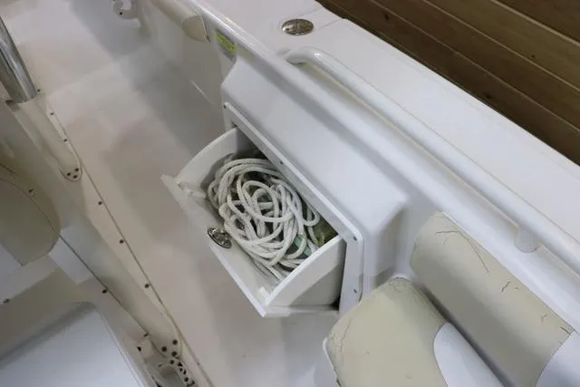 Slide: The Image of 2007 Everglades 223CC boat storage compartment with coiled rope. - 21