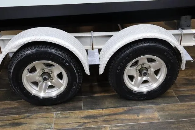 Slide: The Image of Trailer wheels for 2007 Everglades 223CC boat on wooden floor. - 5