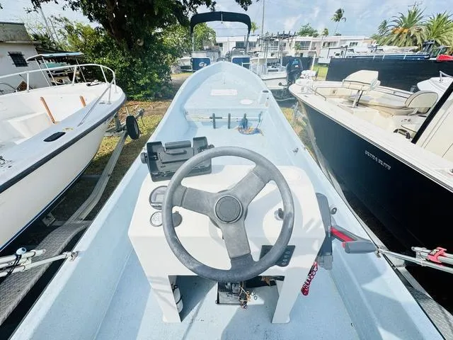 Slide: The Image of Panga 25 boat interior, 2017 model, featuring steering wheel and control panel, docked outdoors. - 3