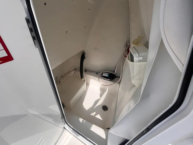 Slide: The Image of 2020 Tidewater 2210 Carolina Bay boat interior storage compartment with drain and wiring. - 15