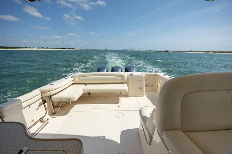 Slide: The Image of 2015 Grady-White Freedom 375 boat cruising on open water, clear sky, spacious seating. - 13
