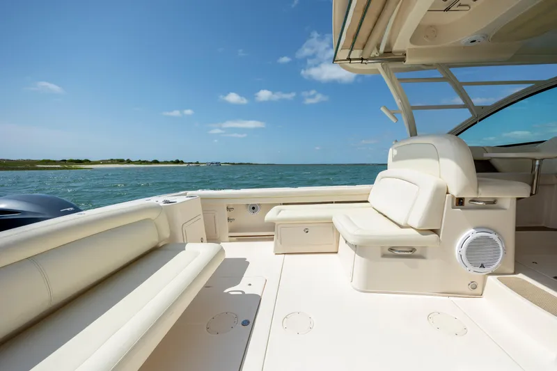 Slide: The Image of 2015 Grady-White Freedom 375 boat interior with seating, ocean view, and clear sky. - 20