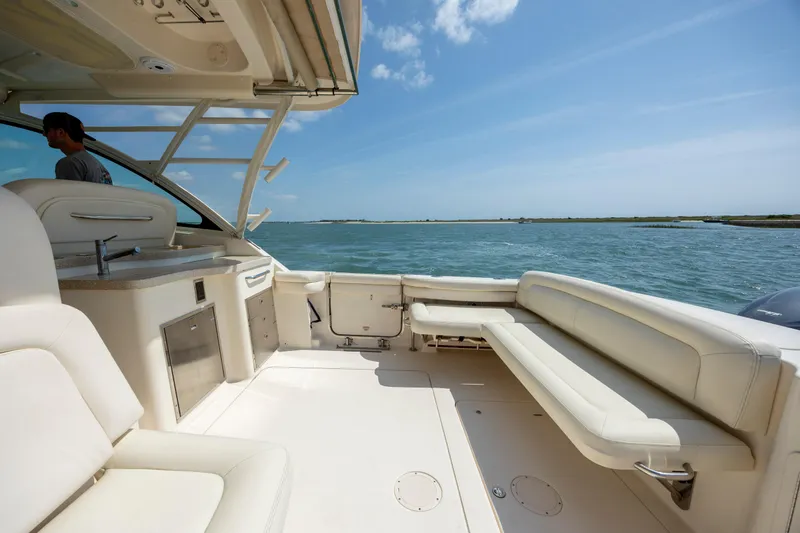 Slide: The Image of 2015 Grady-White Freedom 375 boat interior with seating, overlooking calm waters. - 21