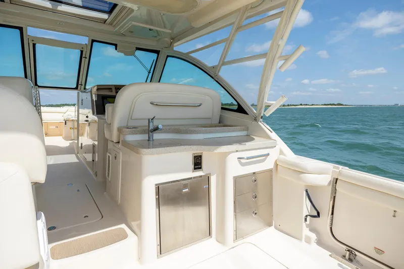 Slide: The Image of 2015 Grady-White Freedom 375 boat interior with ocean view, featuring luxurious seating and amenities. - 23