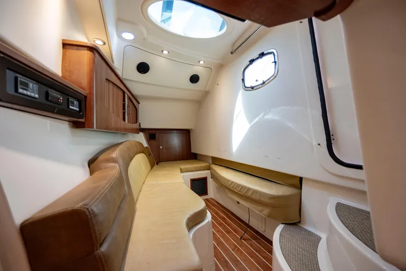 Slide: The Image of Interior of 2015 Grady-White Freedom 375 boat, featuring cozy seating and elegant wood finishes. - 34